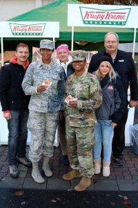 Bakery associates Klaus Schlosser, Silke Garst, Sarah Unterweger and Bill Keller present Krispy Kreme doughnuts to an Airman and Soldier.