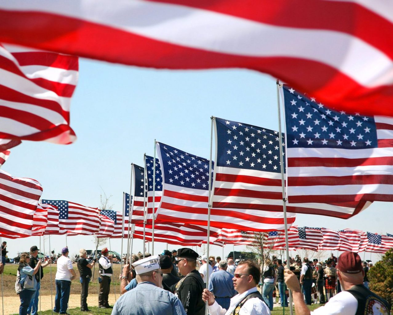 090424-N-3271W-021 VAN METER, Iowa (April 24, 2009) More than 500 veterans who escorted the unclaimed remains of seven Iowa veterans to their final resting place at the Iowa Veterans Cemetery line the procession route with American flags after providing a motorcycle escort for the remains. The ceremony coincided with Des Moines Navy Week, one of 22 Navy Weeks planned across America in 2009. Navy Weeks are designed to show Americans the investment they have made in their Navy and increase awareness in cities that do not have a significant Navy presence. (U.S. Navy photo by Senior Chief Mass Communication Specialist Gary Ward/Released)