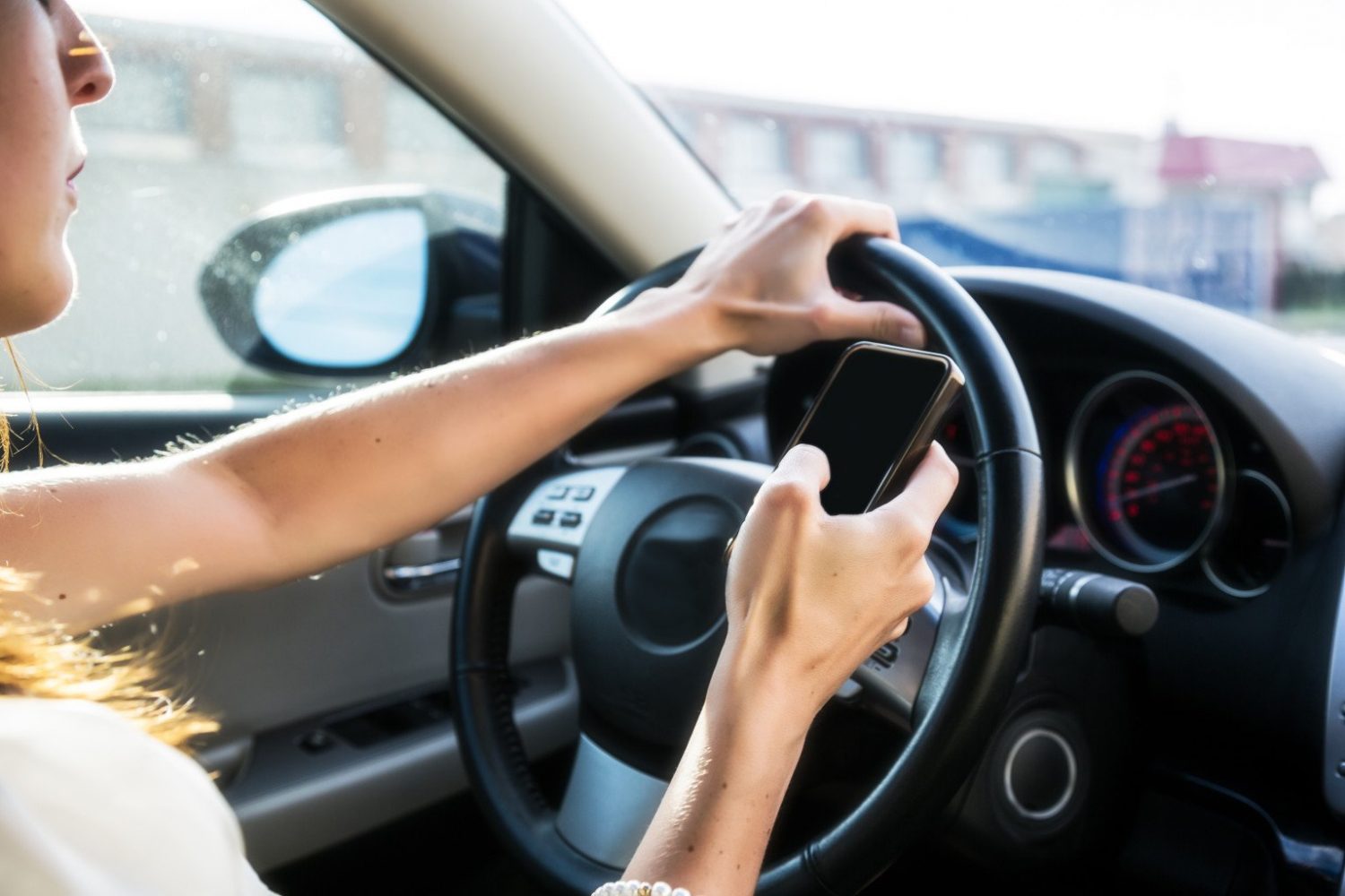 o-DISTRACTED-DRIVING A young woman with long hair texting while driving.