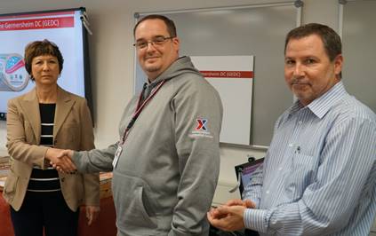 image001 Acting Loss Prevention Manager Jason Taylor, center, receives a coin from Executive Vice President and Chief Logistics Officer Karen Stack for his role in ensuring all safety and security measures are current and associates are educated in proper procedures. They are joined by Alan French, vice president of the Logistics Directorate.