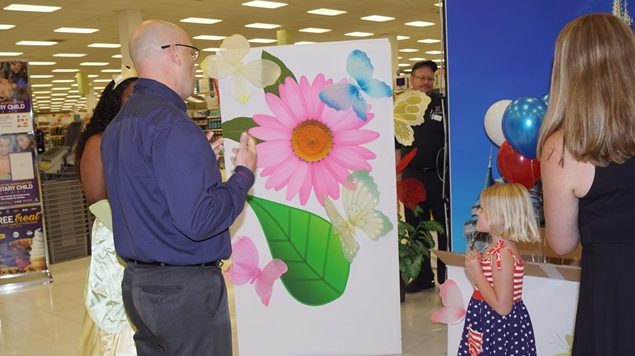 DavisMonthanSurprise General Manager Mikel Hunter builds anticipation for little Annabelle Acosta as to what is inside the big box she is about to open.