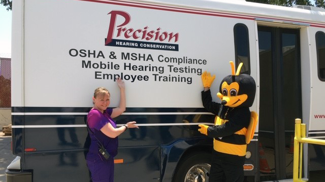 Mobile Hearing Bus_1 Lisa Monda, occupational health nurse at the Exchange’s Waco Distribution Center, and Buzz the Safety Bee show off the mobile hearing bus.