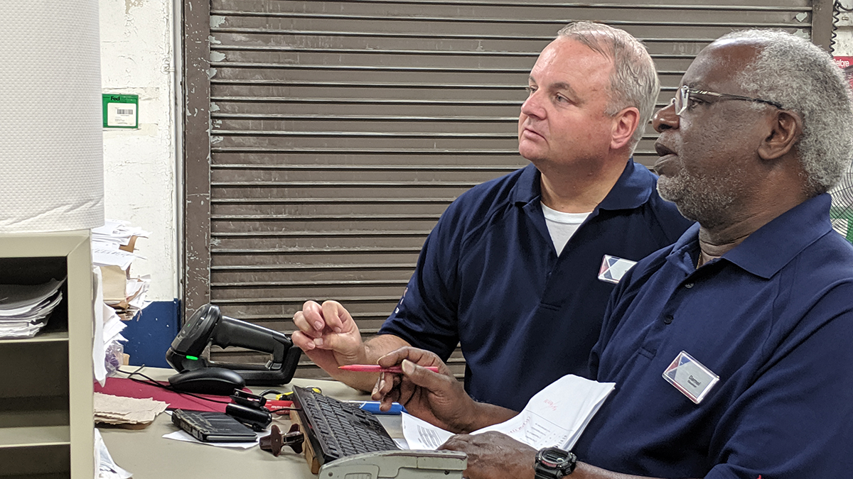 IMG_20190709_123052 At MacDill AFB, Scott Laschkewitsch, left, and Stockroom Receive Dil Cannon pore over warehousing procedures. processes.