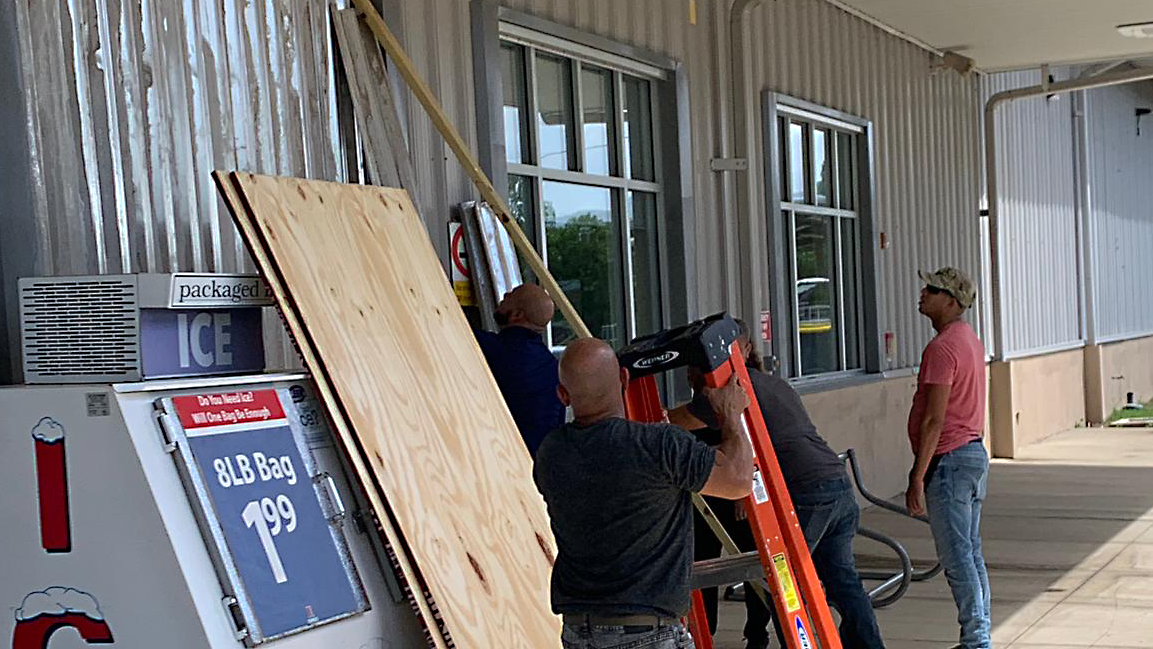 CampSantiago Workmen attach metal shutters to windows of the Camp Santiago Exchange in Puerto Rico to protect the building from storm damage.