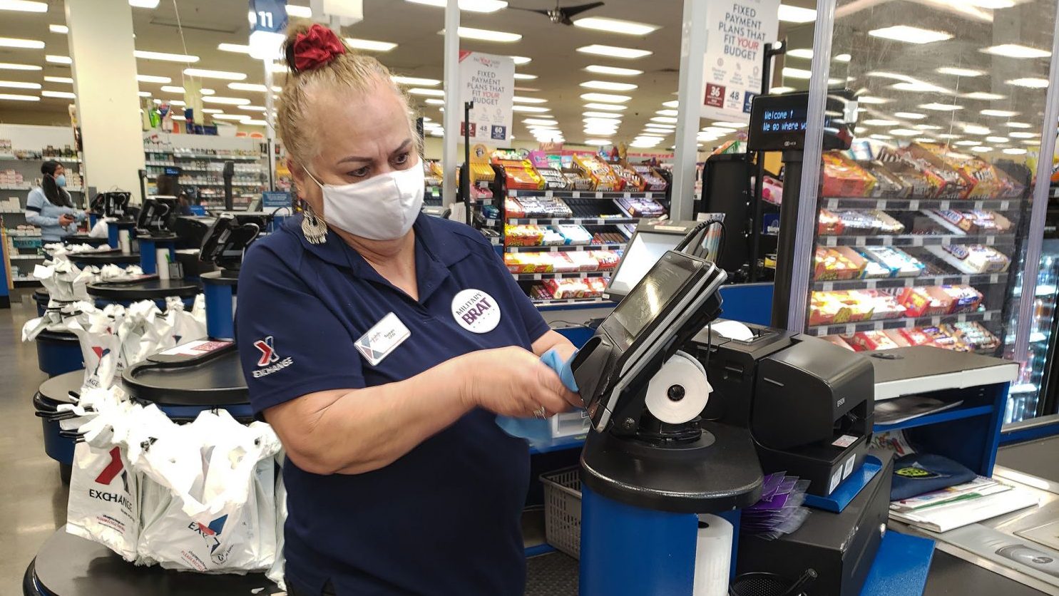 Travis AFB cashier Susan Aninion sanitizes her register’s pin pad. Increased sanitation efforts are just one of the steps Western Region Exchanges are taking to protect shoppers and associates from COVID-19.