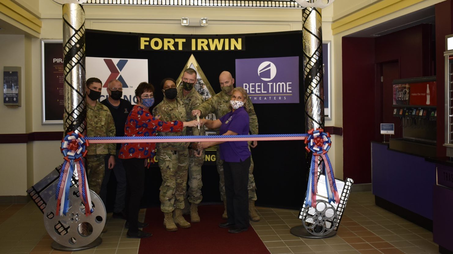 51086093221_3ac089abc3_6k Fort Irwin PX General Manager Holly Elliott (left) and Theater Manager Mercedes Garcia (right), along with Garrison Commander Col. Jeanette Martin, cut the ribbon on the newly renovated Reel Time Theater, which reopened in March.