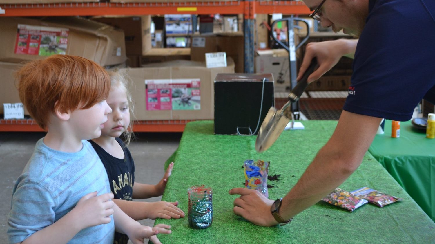 47680563312_3a0fc1d040_k <strong>A Tinker Air Force Base associate shows children how to make planters from recycled bottles and cans during the Exchange's 2019 Earth Day recognition. The kids took the flowers home as gifts to their parents.</strong>