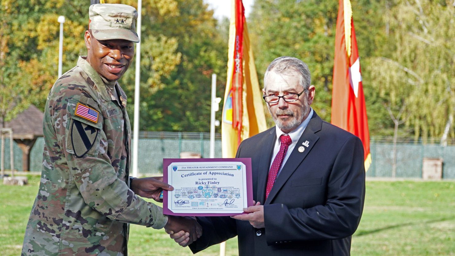 <b>Commanding General Maj. Gen. James M. Smith, 21st Theater Sustainment Command, presents a certificate of appreciation to Exchange Europe/Southwest Asia/Africa Contingency Operations Liaison Rick Finley during a Quality of Life and Civilian of the Quarter Recognition ceremony held Oct. 17 on Panzer Field on Oct. 17 in Kaiserslautern, Germany.