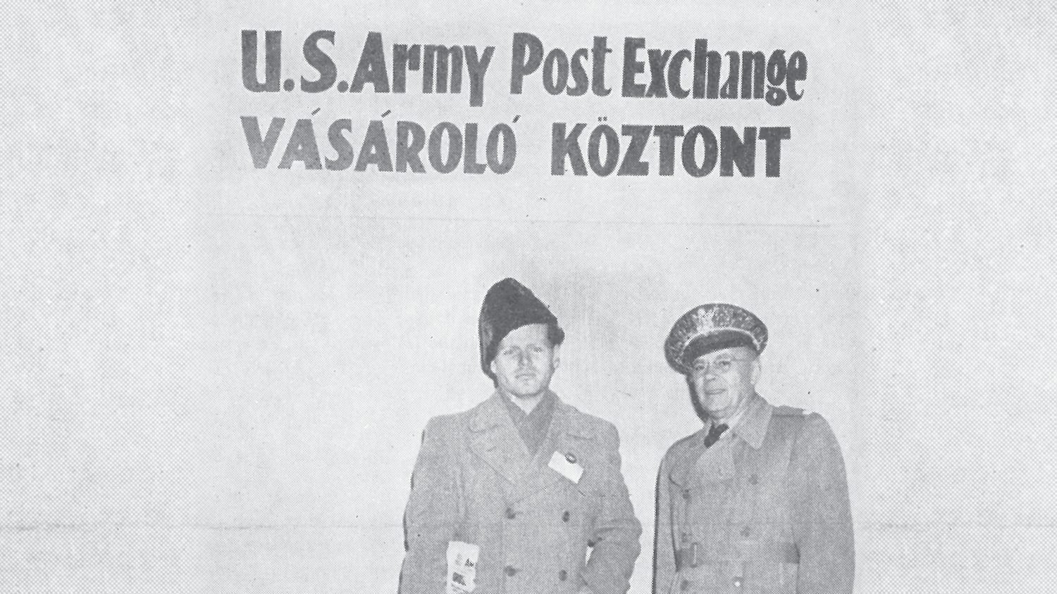 <b>In a January 1957 Exchange Post photo, a Hungarian customer  stands with Lt. Col Ernest Scheuder, Fort Dix Exchange Officer, before a sign identifying one of the shopping centers in Hungarian.</b>