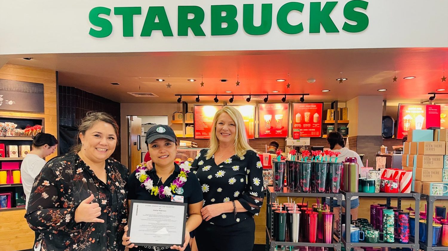 Joselyn Robinson <b>Starbucks District Managers Lani Booker, left, and Angie Rivers award Joselyn Robinson, Hickam Starbucks Manager, the franchise’s Store Leader of the Quarter for the 4th quarter. Robinson and her team set Hawaii’s single-day sales record at $29,585 during Starbucks Holiday Launch.</B>
