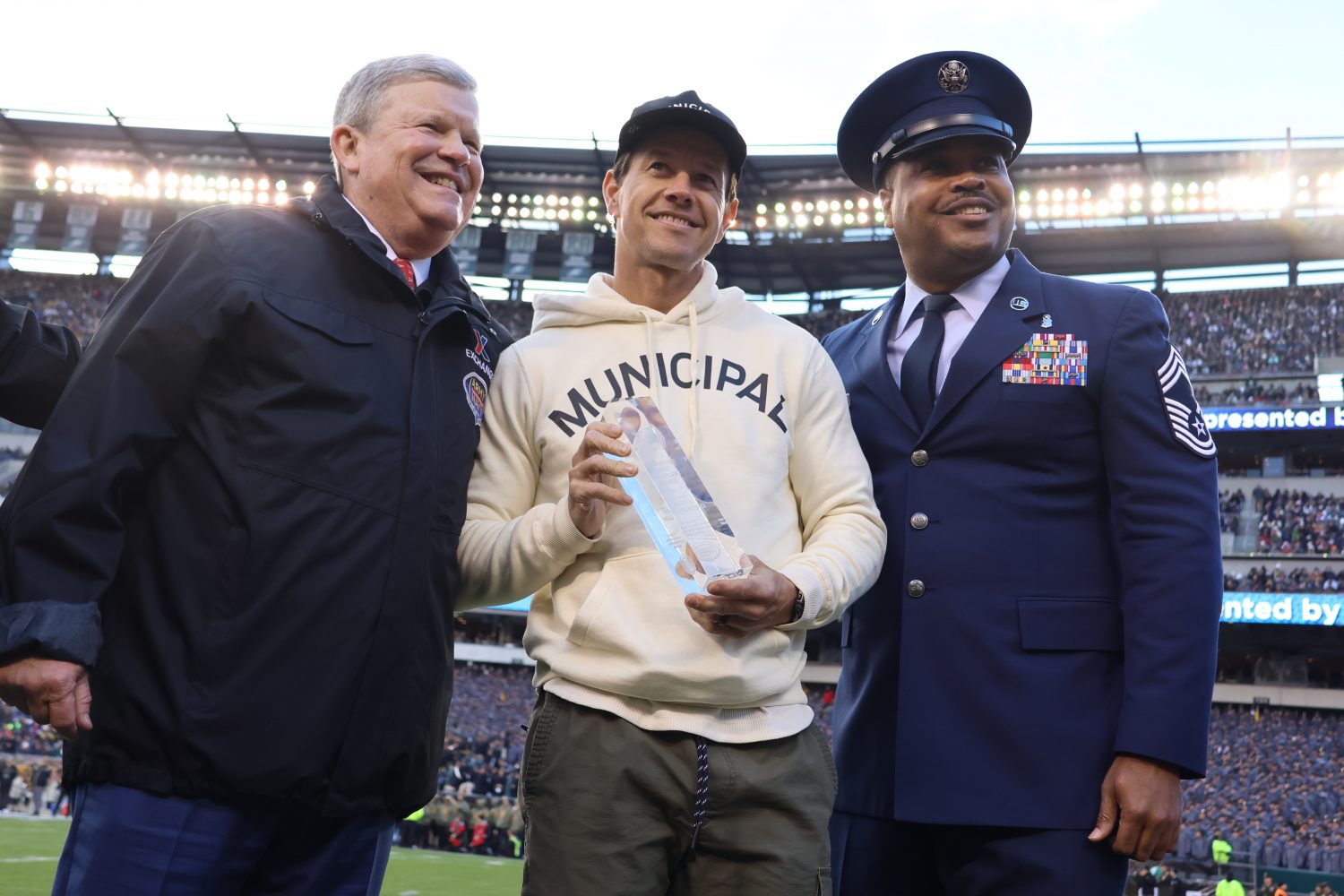 Actor-producer Mark Wahlberg, recipient of the 2022 Quality-of-Life Force Multiplier Award, with Exchange Director/CEO Tom Shull and Senior Enlisted Advisor Air Force Chief Master Sgt. Kevin Osby, on the field at the Army-Navy Game.</b>