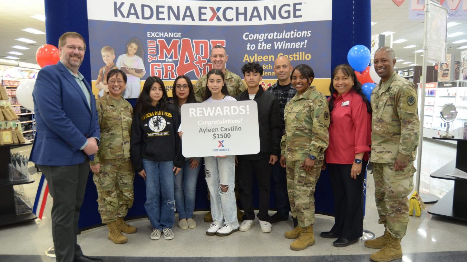YMTG_Kadena_second-place winner <B>Ayleen Castillo, sixth-grader at Kadena Middle School, poses with a $1,500 Exchange gift card for winning second place in the You Made the Grade sweepstakes in December with the Exchange PAC Region command team, 18th Wing Mission Support Group commander, Exchange leadership and family members who attended the awards presentation. (U.S. Army Photo by Staff Sgt. Mark A. Kauffman)</b>