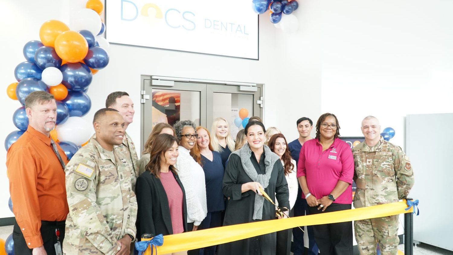 <b>Leading the ribbon-cutting at the Kaiserlautern Military Community Exchange's DOCS Dental office are, from left: SGM Jason Urquhart, 86th Airlift Wing Deputy Director Racquel Fischer (black blazer, pink shirt) , Ms. Randolph, GM Michelle Weisshaar (Center with scissors), DOCS Office Manager Jacqueline Hailey (White blazer), SBM Krystal Mclarin (Pink X shirt), Mission Support Group Commander COL James Cunningham<.b>