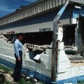 A female Seaman looks at damage to Trader Andy's Hut after an 8.1-magnitude earthquake struck Guam in 1993.