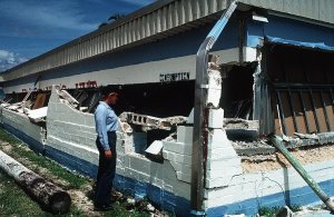 A female Seaman looks at damage to Trader Andy's Hut after an 8.1-magnitude earthquake struck Guam in 1993.