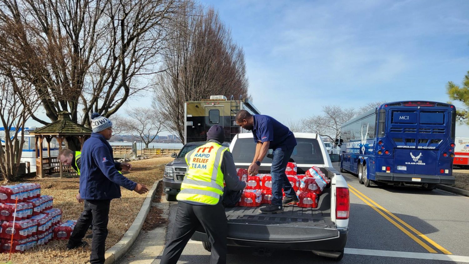 Potomac <b>Dominique Welborn, left, and Dion McIntosh, in truck bed, transported bottled water from Joint Base Andrews' Westside Express to Joint Base Anacostia-Bolling, then offloaded the water at the Potomac plane-helicopter crash recovery site.<b>