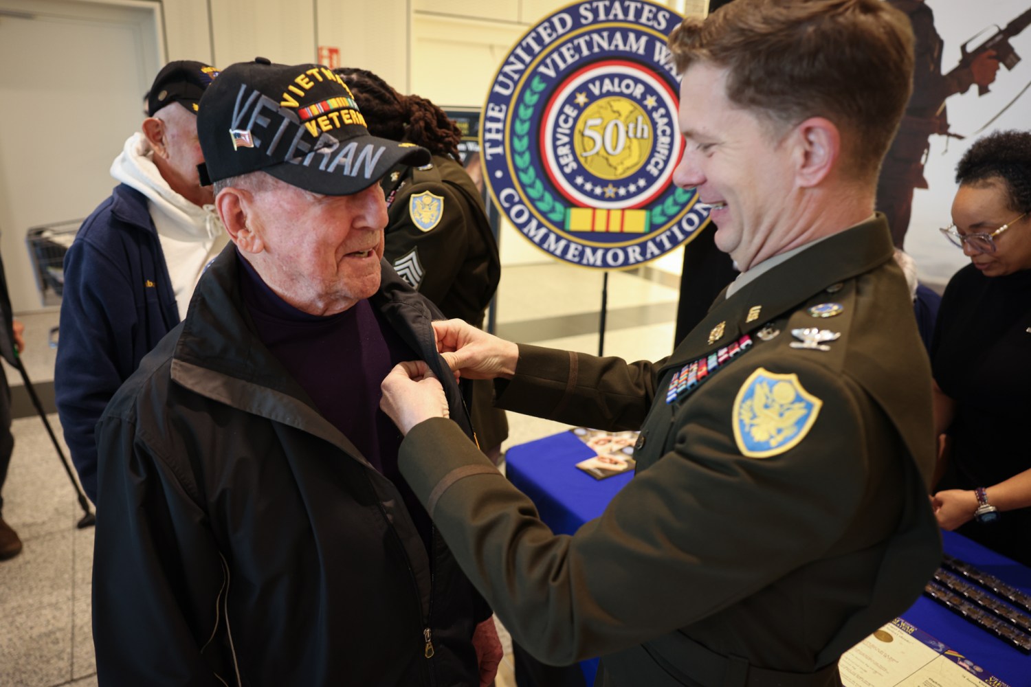Col. Everett "Bud" Lacroix, Exchange Europe/Southwest Asia/Europe Region, places a commemorative pin  on a Veteran's lapel during Vietnam War Veterans Day ceremonies at Ramstein Air Base in Germany.