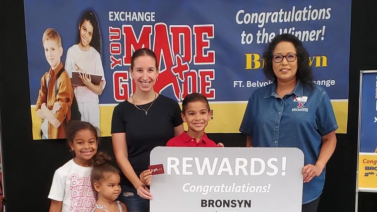 <b>Bronsyn Dungey accepts his You Made the Grade Prize at the Fort Belvoir Exchange, accompanied by his mother, Megan Dungey, and his sisters. At right is Fort Belvoir Store Manager Nanami Taniguchi.