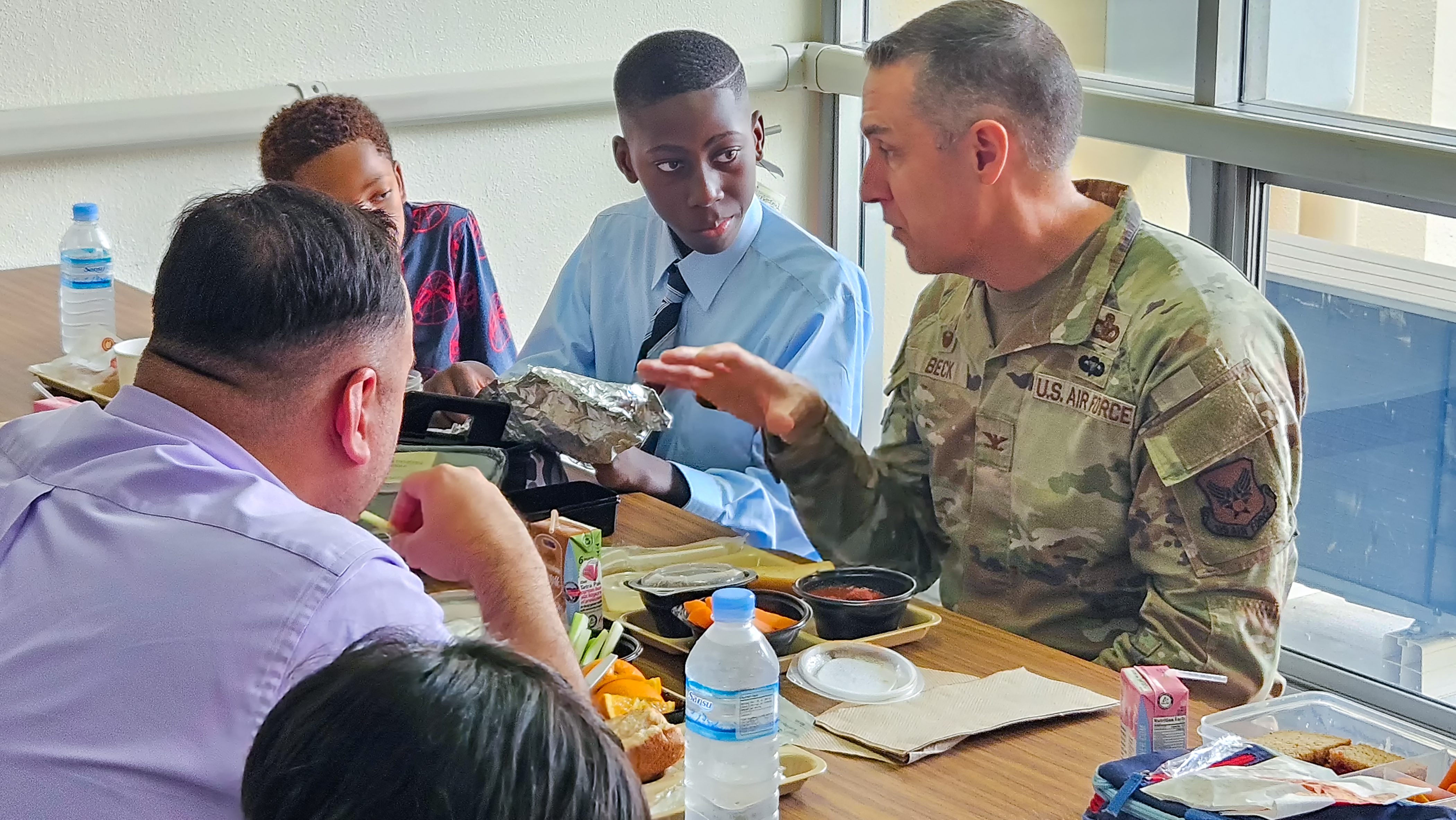 Yokota Elementary School fifth grader Nii Borketey and Pacific Region Commander Col. Jason Beck with two others at lunch table.