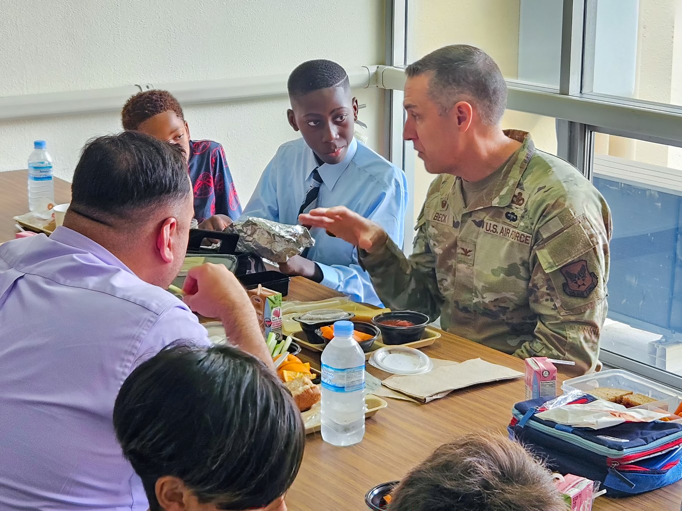 Yokota Elementary School fifth grader Nii Borketey and Pacific Region Commander Col. Jason Beck with two others at lunch table.