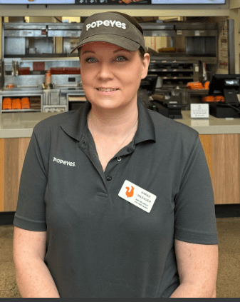 Karah Zinski wearing Popeyes shirt and cap.