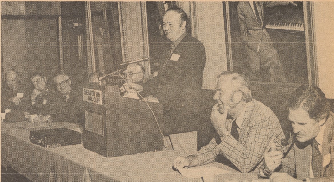 Newspaper clipping of men at dais during first AREA board meeting.