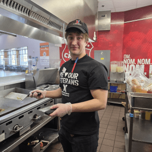 Justin Hanlon photo. He is wearing an Exchange food court cap and a We Love Our Veterans T-shirt.