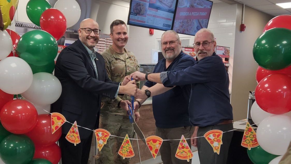 Four men cutting the ribbon at RAF Molesworth Express grand reopening.