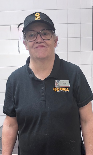 Susanne (Susi) Igel-Blackwell photo. She is wearing a Qdoba cap and polo.