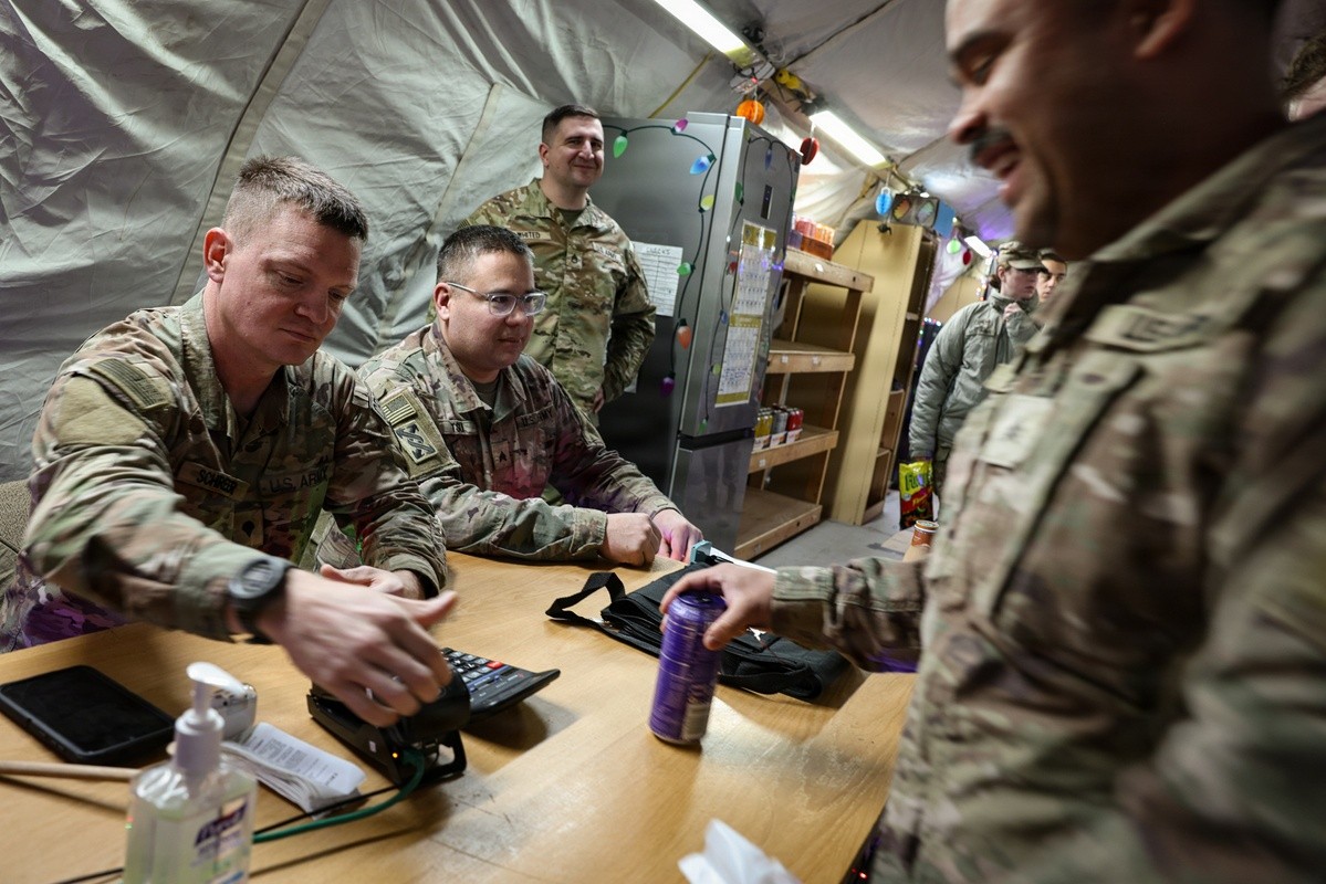 Four Soldiers around a table inside Exchange tent.