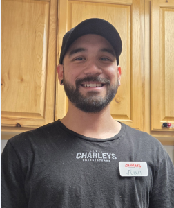 Juan Gomez head shot. He is wearing a dark gray Charleys T-shirt.