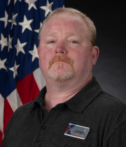 Kenneth Holden head shot with USA flag.