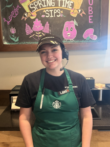 Alexis Sessions head shot. She is wearing a Starbucks cap, apron and T-shirt.