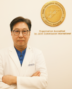 Dr. Woo-Sung Yun head shot. He is wearing glasses and a white lab coat.