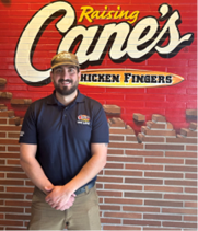 Luis Espino with Raising Cane's sign behind him.