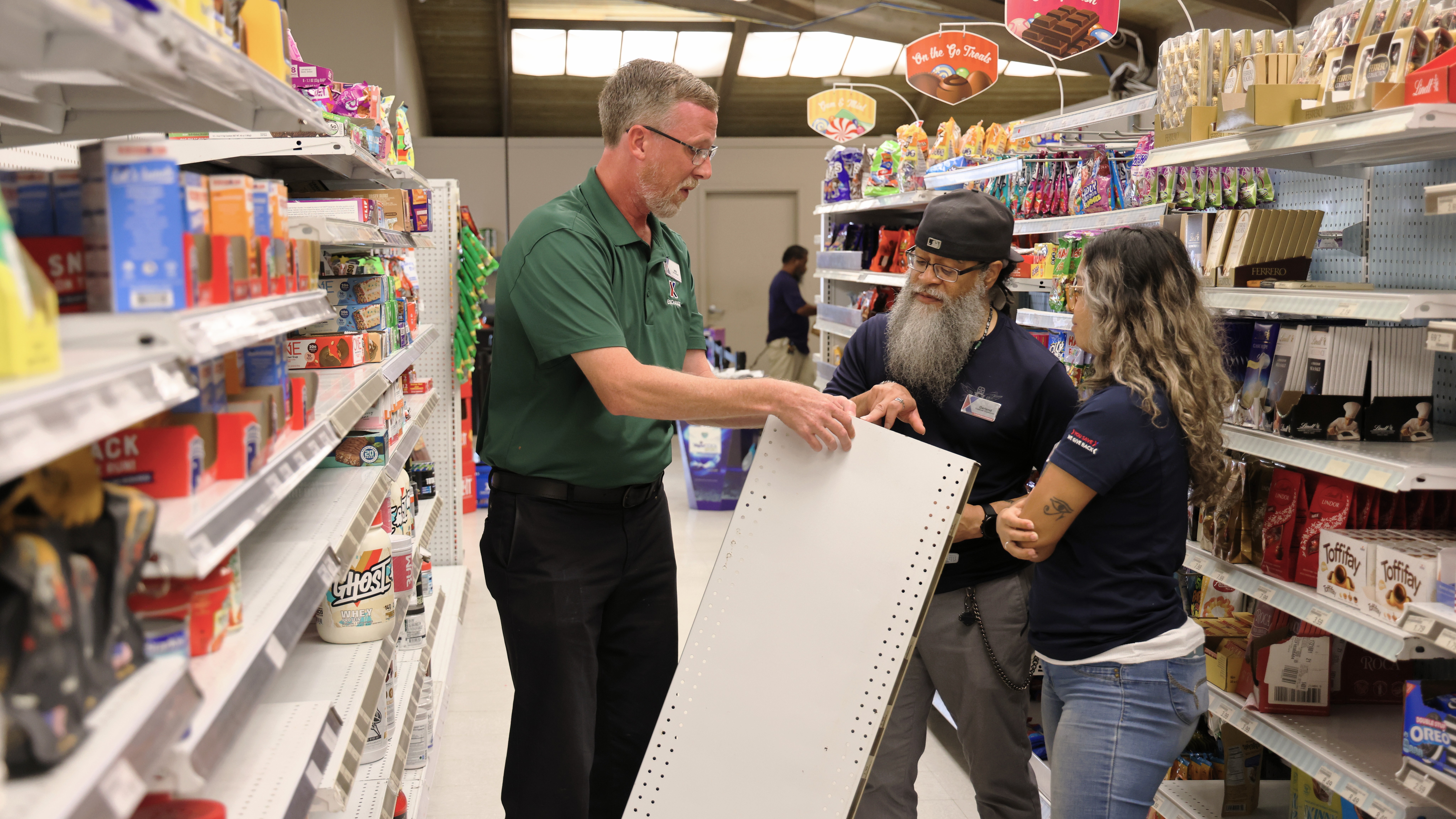 Three associates working on shelving at the Kwajalein Exchange