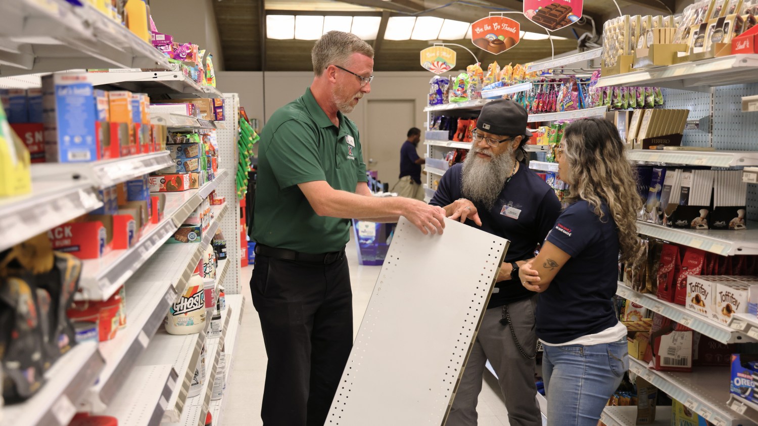 Three associates working on shelving at the Kwajalein Exchange