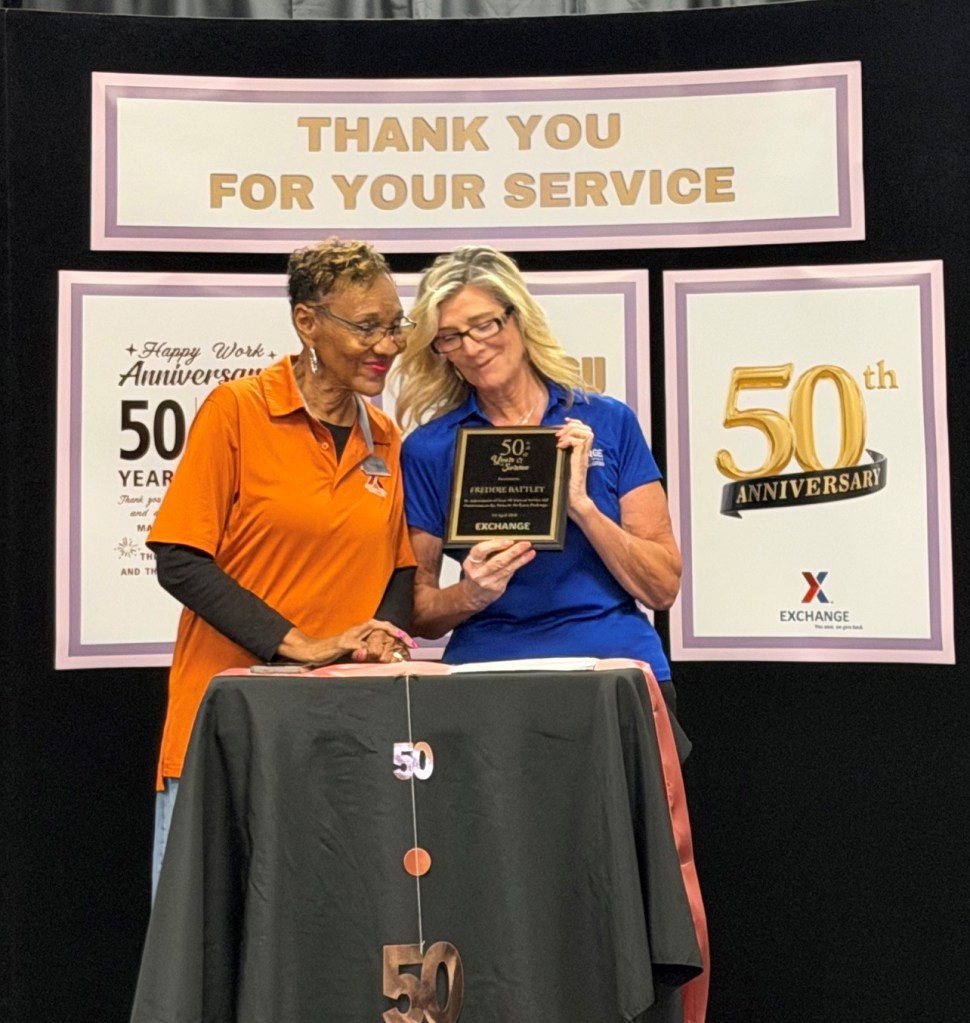 Ms. Freddie Battley receiving 50-year award from MacDill main store manager.